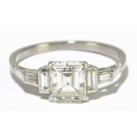 A white metal diamond solitaire ring with central emerald cut stone, clarity WS, colour J-K,