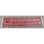 An Eastern style runner with stylised motifs on a red and blue ground, length 299cm, width 76cm.