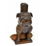 A decorative Black Forest brush hold modelled as a seated bulldog with glass eyes, height