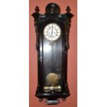 A 19th century ebonised Vienna style wall clock with arched mount, the enamelled dial set with Roman