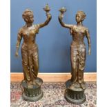 A large near pair of bronze lamps, representing European maidens wearing floral dresses,