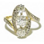 A yellow metal and white metal diamond set ring with pierced swept design, the central stone approx.