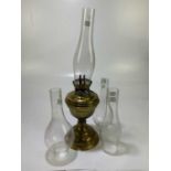 A Victorian brass oil lamp with repoussé decoration to the foot rim, with chimney, height 50cm,