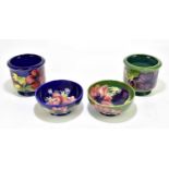 MOORCROFT; two footed bowls decorated in 'Anemone' pattern, one on green ground, one on blue ground,
