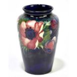 WALTER MOORCROFT; a vase decorated in 'Anemone' pattern on a blue ground, height 13cm. Condition
