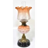 A Victorian oil lamp, the orange and clear glass shade with wavy rim having etched decoration with