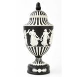 WEDGWOOD; a black basalt pedestal urn and cover, with black and white fluted decoration above a
