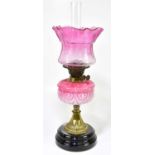 A Victorian glass oil lamp, the cranberry and clear glass shade with etched scrolling decoration