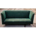 A green upholstered enclosed sofa on turned supports, width 183cm.