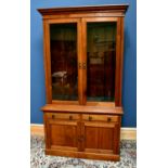 An Edwardian walnut bookcase with glazed upper section above base of two drawers and two cupboard