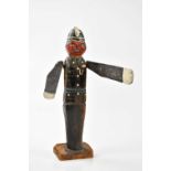 An unusual carved wooden model of a policeman, with rotating arms, height 33cm.