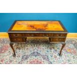 A 1950s mahogany kneehole desk with tooled brown leather inset top above an arrangement of five