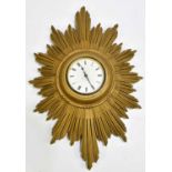 A 1920s/30s Art Deco gilt sunburst wall clock, the enamel dial set with Roman numerals, width