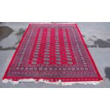 A hand knotted red ground Bokhara carpet, 293 x 198cm.