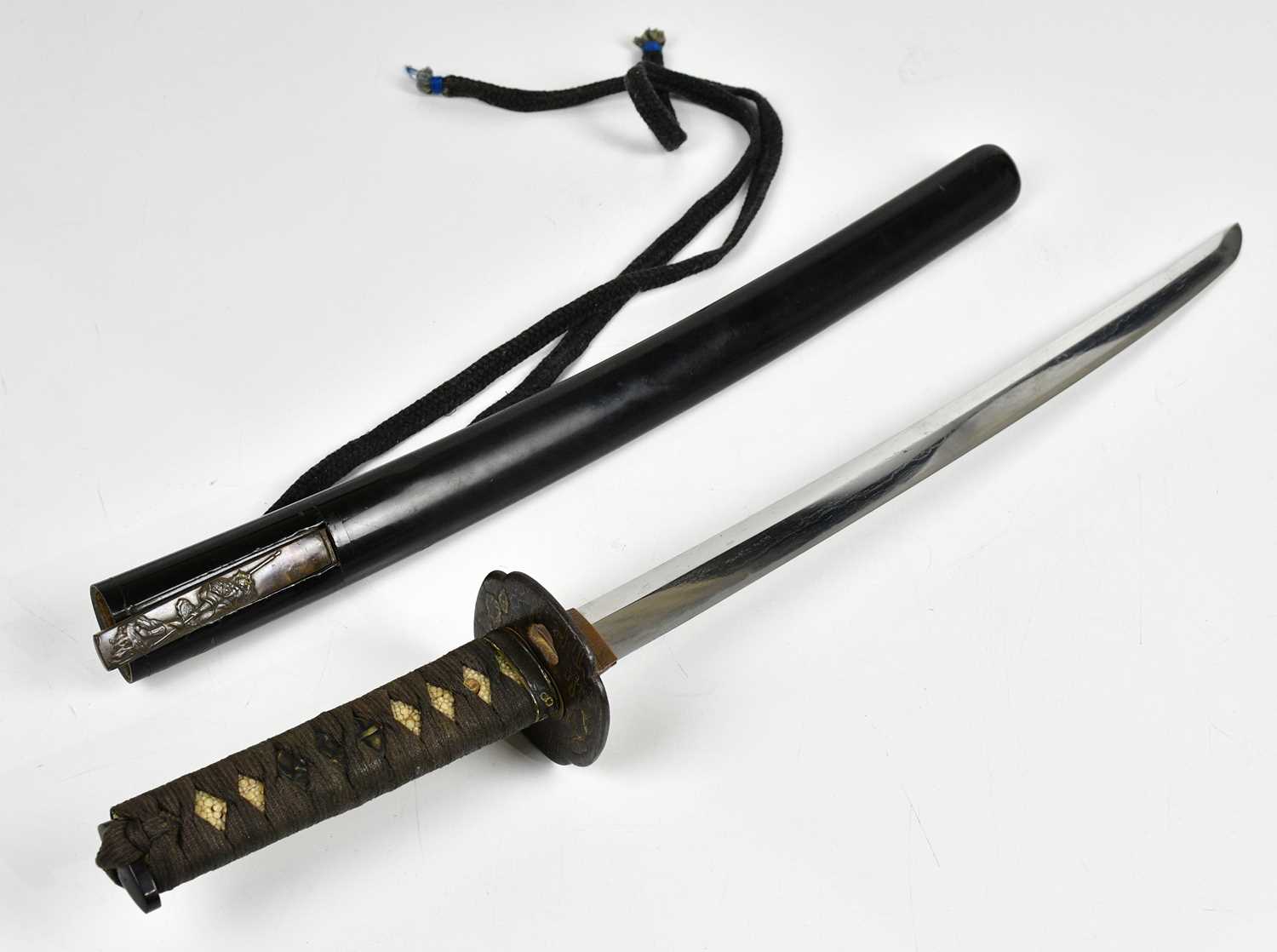 A Japanese Wakizashi sword, the shagreen grip with applied Menuki, above the Tsuba decorated with