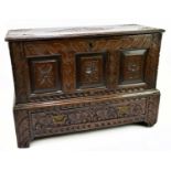 An 18th century miniature carved oak coffer, with panelled front above single base drawer, width