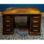 A 1920s/30s oak knee hole twin pedestal desk, with an arrangement of eight drawers, width 138cm,