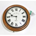 A circa 1900 oak circular wall clock with painted dial inscribed 'Prescot Clock Co, Prescot', with