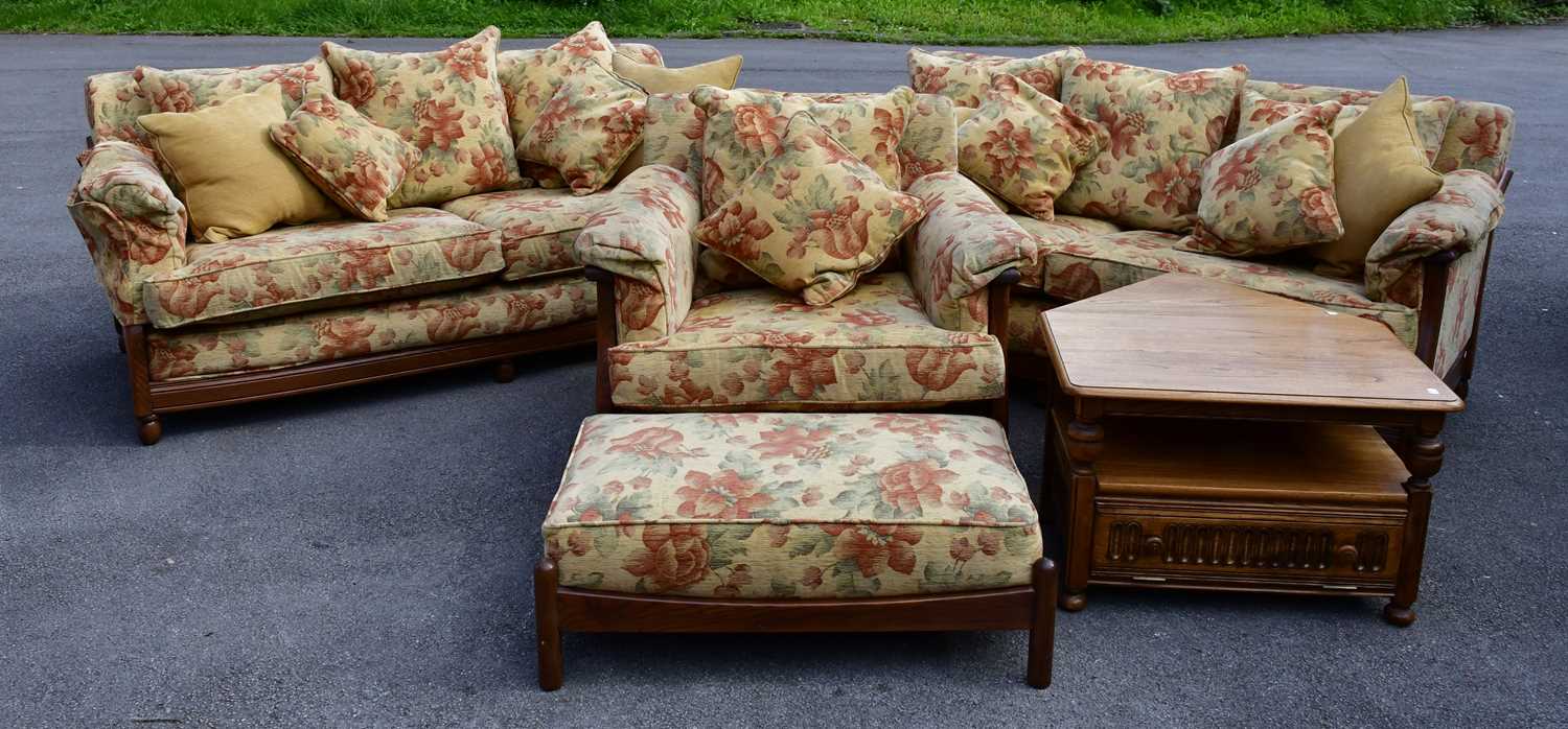 ERCOL; a four piece lounge suite comprising two two-seater sofas, an armchair and a footstool,