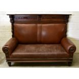 A 19th century carved walnut settle, the raised back with two carved panels, with leather back and