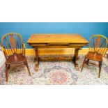 A reproduction oak draw-leaf dining table with carved floral detail to the stretcher, length when