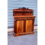 A Victorian rosewood chiffonier with raised back, having scrolling detail on two turned columns