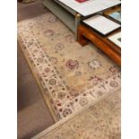 Two contemporary rugs, each decorated with stylised and floral motifs on a cream/ivory ground,