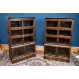 A pair of oak four tier bookcases with hinged doors, width 88cm, depth 27cm, height 145cm.