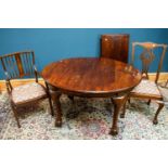 An early 20th century mahogany wind-out extending dining table with additional leaves on cabriole