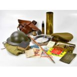 A mixed lot of military items to include a WWI shell casing, a deactivated bullet, a leather