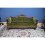 A Victorian carved mahogany settee with scroll back on turned bun feet upholstered in a green button