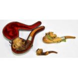 Three late 19th century Meerschaum pipes, one with leather case.