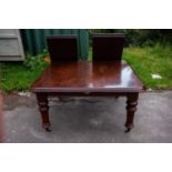 A Victorian mahogany pull-out extending dining table with two extra leaves, on turned supports, when