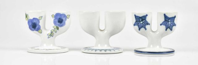 TROIKA POTTERY; three double egg cups, to include an unusual example with floral decoration, each