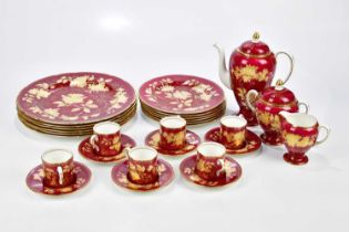 WEDGWOOD; a gilt decorated part tea and dinner service with floral sprays on a burgundy ground.