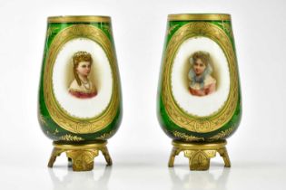 A pair of late 19th century Bohemian green glass vases, each with hand painted opaque panels,
