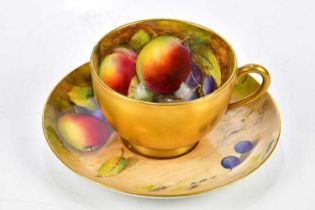 W. H. AUSTIN FOR ROYAL WORCESTER; a hand painted teacup and saucer, decorated with fruit, signed.