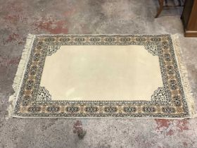 A modern rug on gold/brown ground. 140x200cm