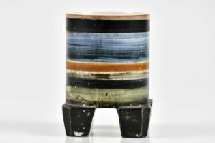 TROIKA POTTERY; a rare and unusual footed cylinder with linear decoration in colours of orange,