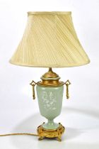A late 19th century pâte-sur-pâte table lamp with ormolu mount and drop handles in the aesthetic