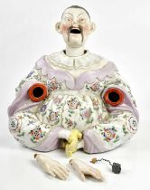 A late 19th century German hand painted porcelain model of a seated nodding figure in the style of