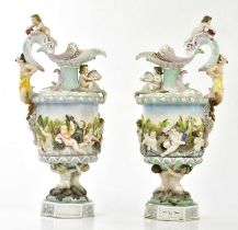 A pair of late 19th century Continental porcelain ewers relief decorated with cherubs and mythical