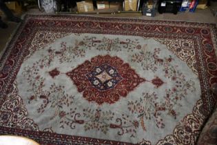 A large Eastern hand knotted blue ground rug, decorated to the centre with a stylised motif, 415cm x