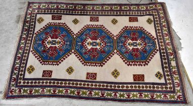 An Eastern style rug with central elephant foot decoration on a red and ivory ground.