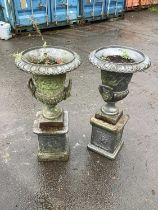 A pair of early 20th century cast iron urns on plinth bases, 85cm.