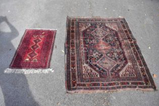 An Eastern style carpet with stylised floral decoration, together with a red ground prayer mat (2).