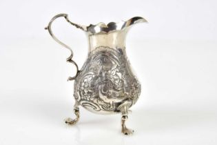 A Victorian hallmarked silver cream jug of baluster form, embossed with birds, rabbits and floral