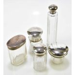Five clear glass silver mounted toilet jars, various hallmarks (one with associated glass base and