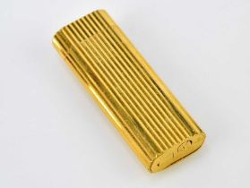 CARTIER; a boxed Must de Cartier gold plated ribbed lighter.