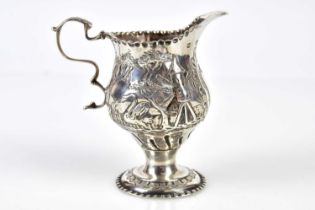 A George III hallmarked silver pedestal jug embossed with farming scenes and Dutch windmill,